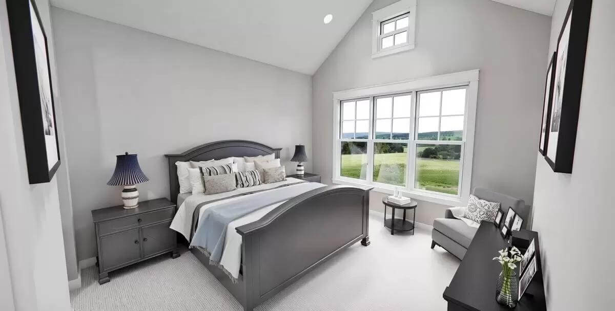 Primary bedroom with dark wood furnishings under a cathedral ceiling.