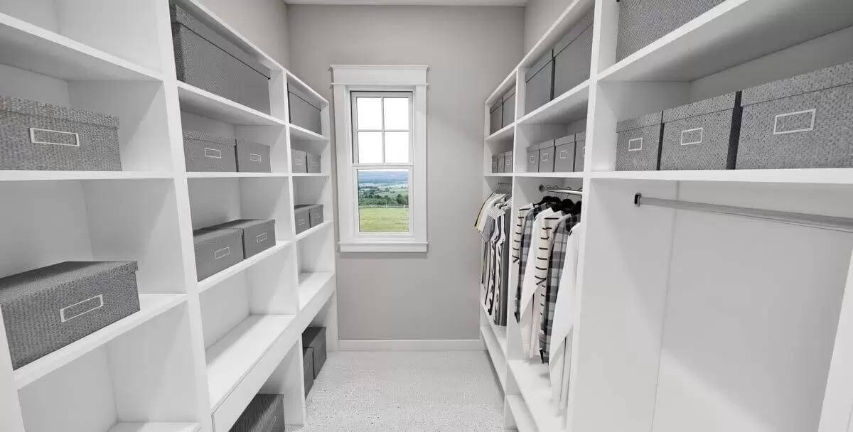 Primary walk-in closet with ample storage and a small window.