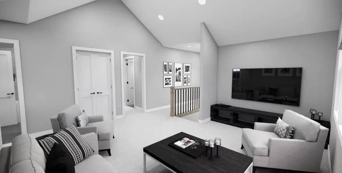Loft with gray seats and a wall-mounted TV under a vaulted ceiling.
