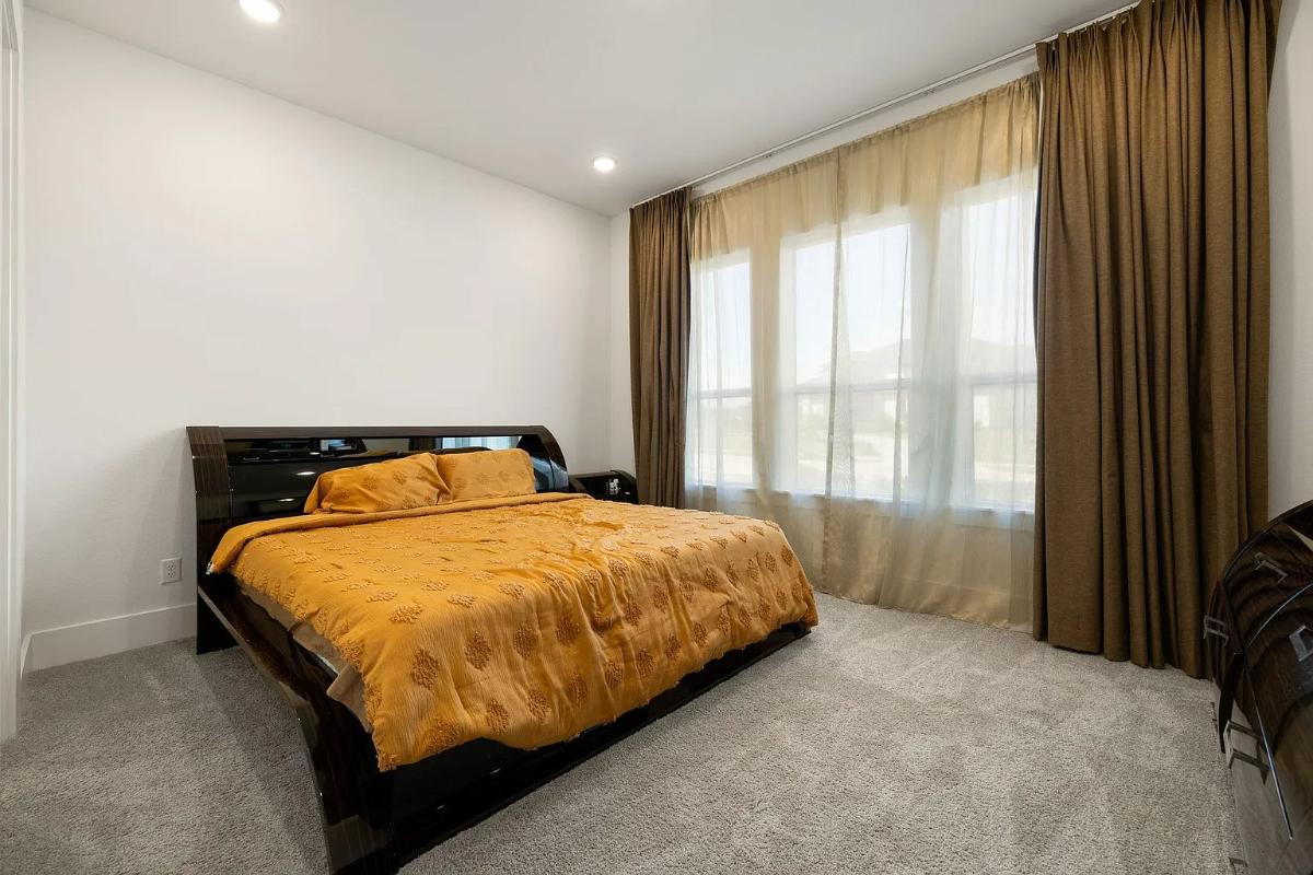 Bedroom with a large bed and carpet flooring.