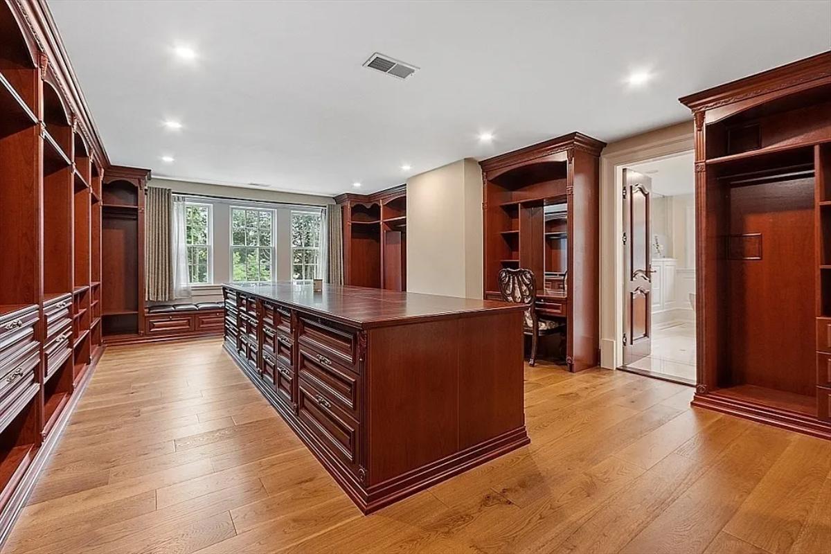 Walk-in closet with hardwood floors.
