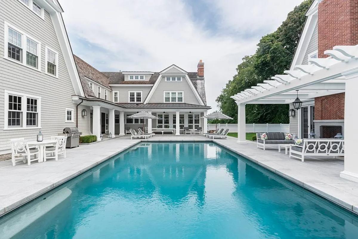 Pool with a dining area and lounge chairs.