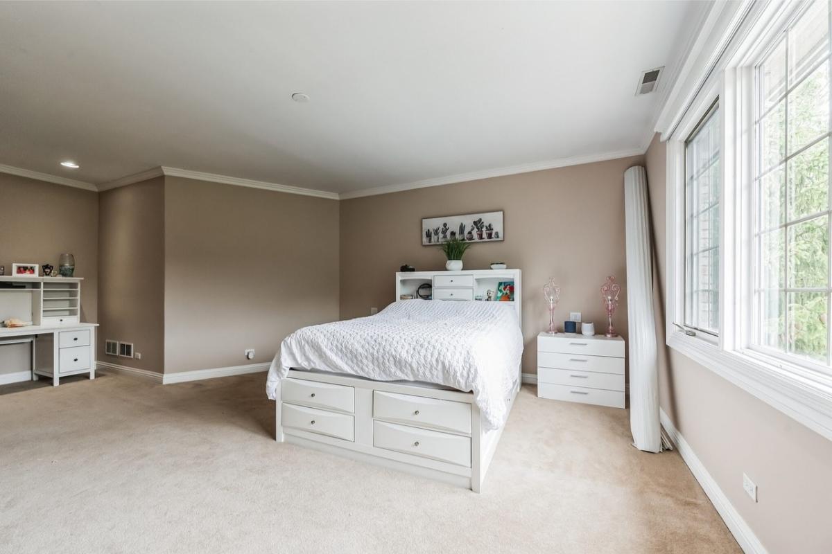 Bedroom with a large bed and carpet flooring.