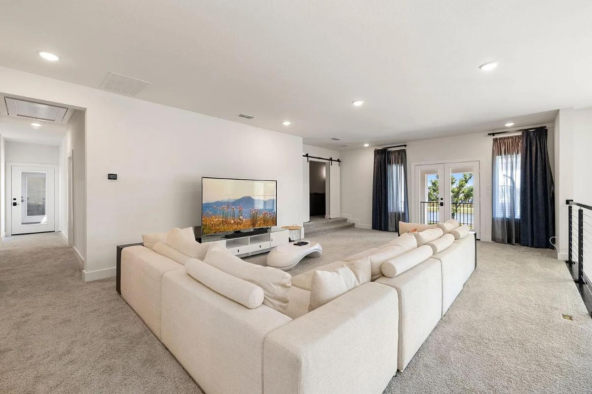 Living room with a TV and carpet flooring.