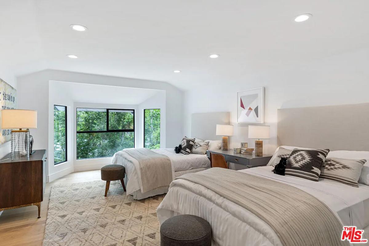 Bedroom with two beds and hardwood floors.