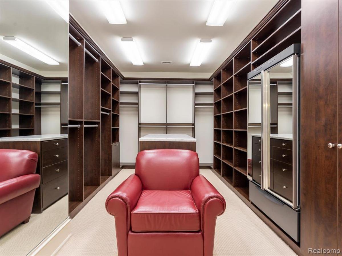 Walk-in closet with custom cabinetry and shelves.