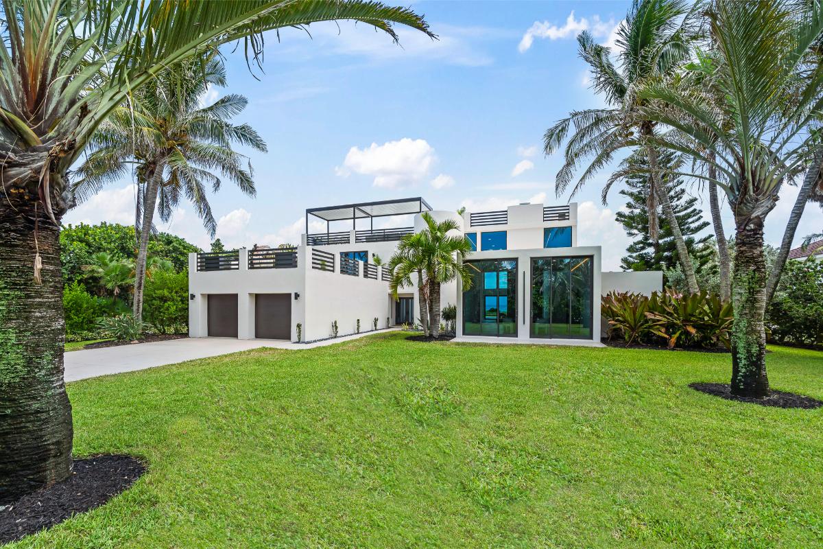 Front view of the house with a large green lawn.