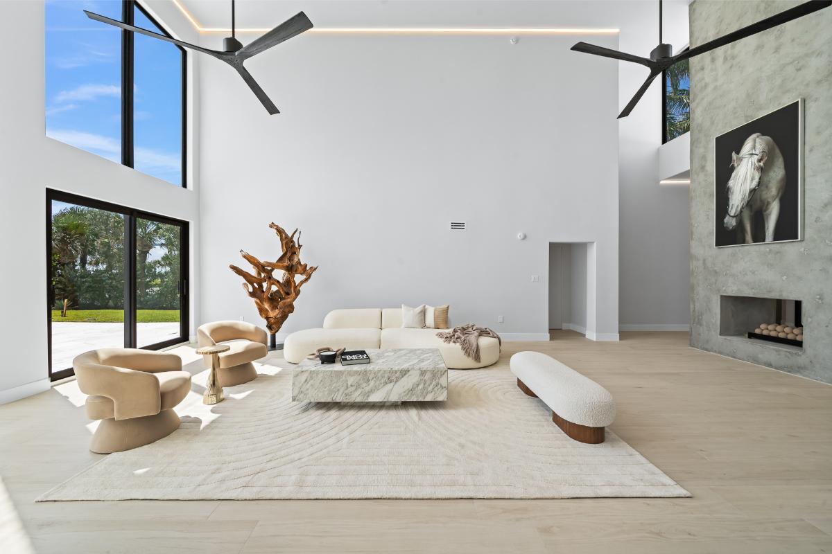 Living room with high ceilings, sliding glass doors and a fireplace.