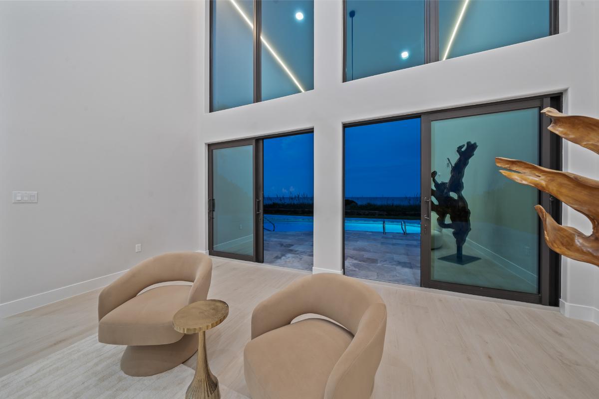 Living room with high ceilings and sliding glass doors.