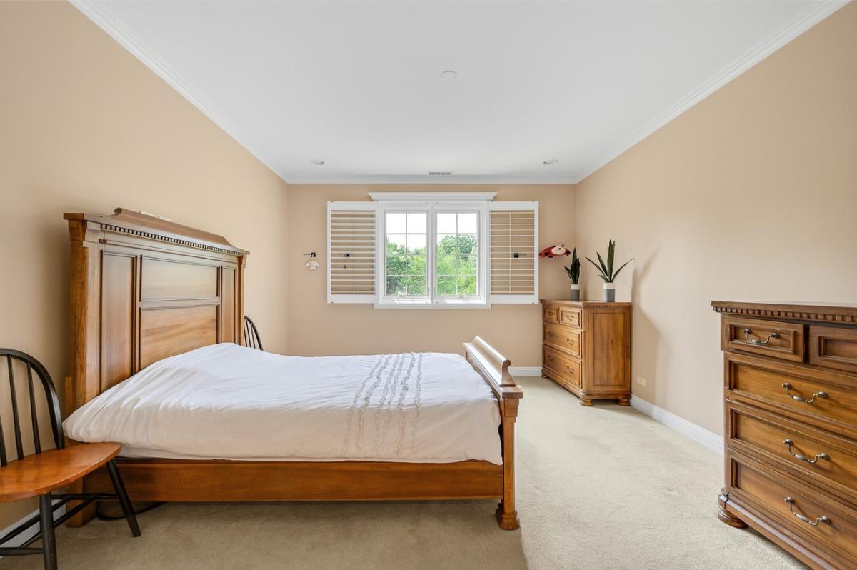 Bedroom with a large bed and carpet flooring.