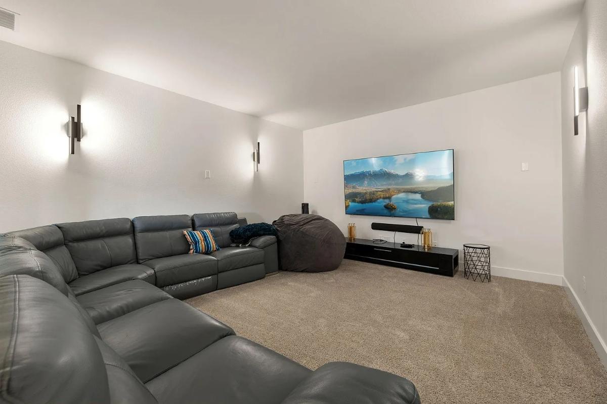 Media room with a TV and carpet flooring.