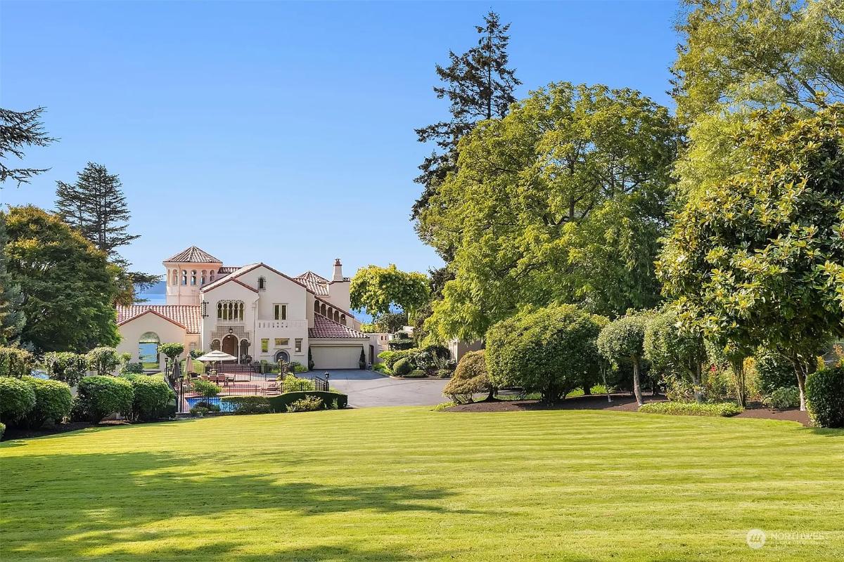 Front view of the mansion with a large green lawn.