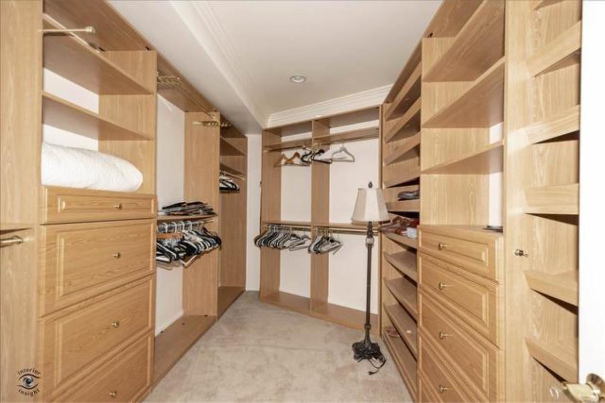 Walk-in closet with custom cabinetry and shelves.