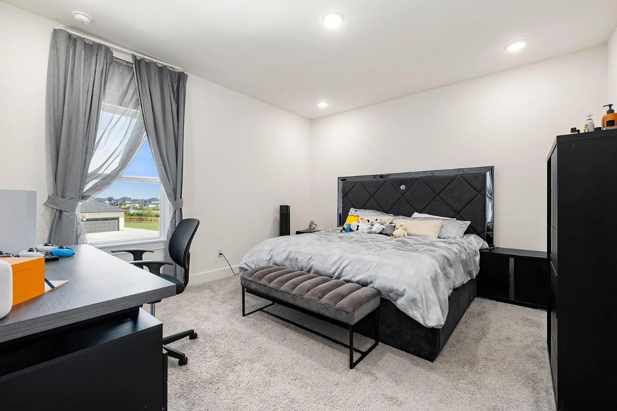 Bedroom with a large bed and carpet flooring.