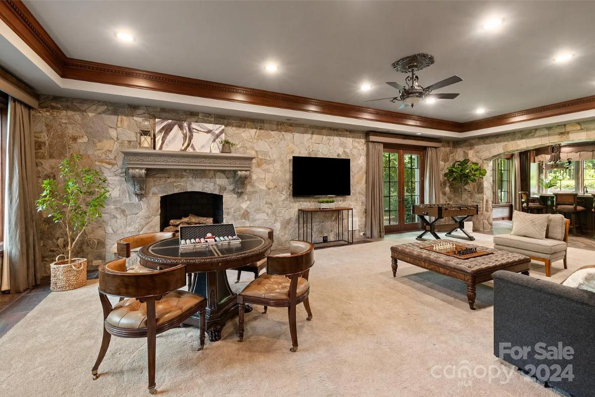 Recreation room with a fireplace and carpet flooring.