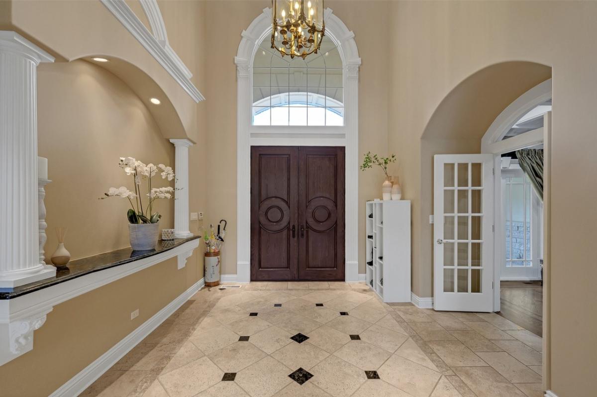 Foyer with a chandelier and hardwood doors.