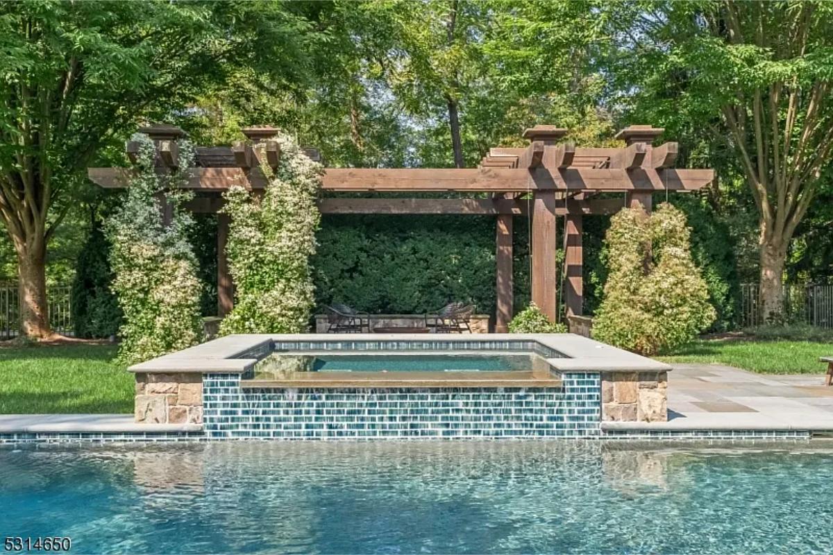 Pool with a jacuzzi and a pergola,