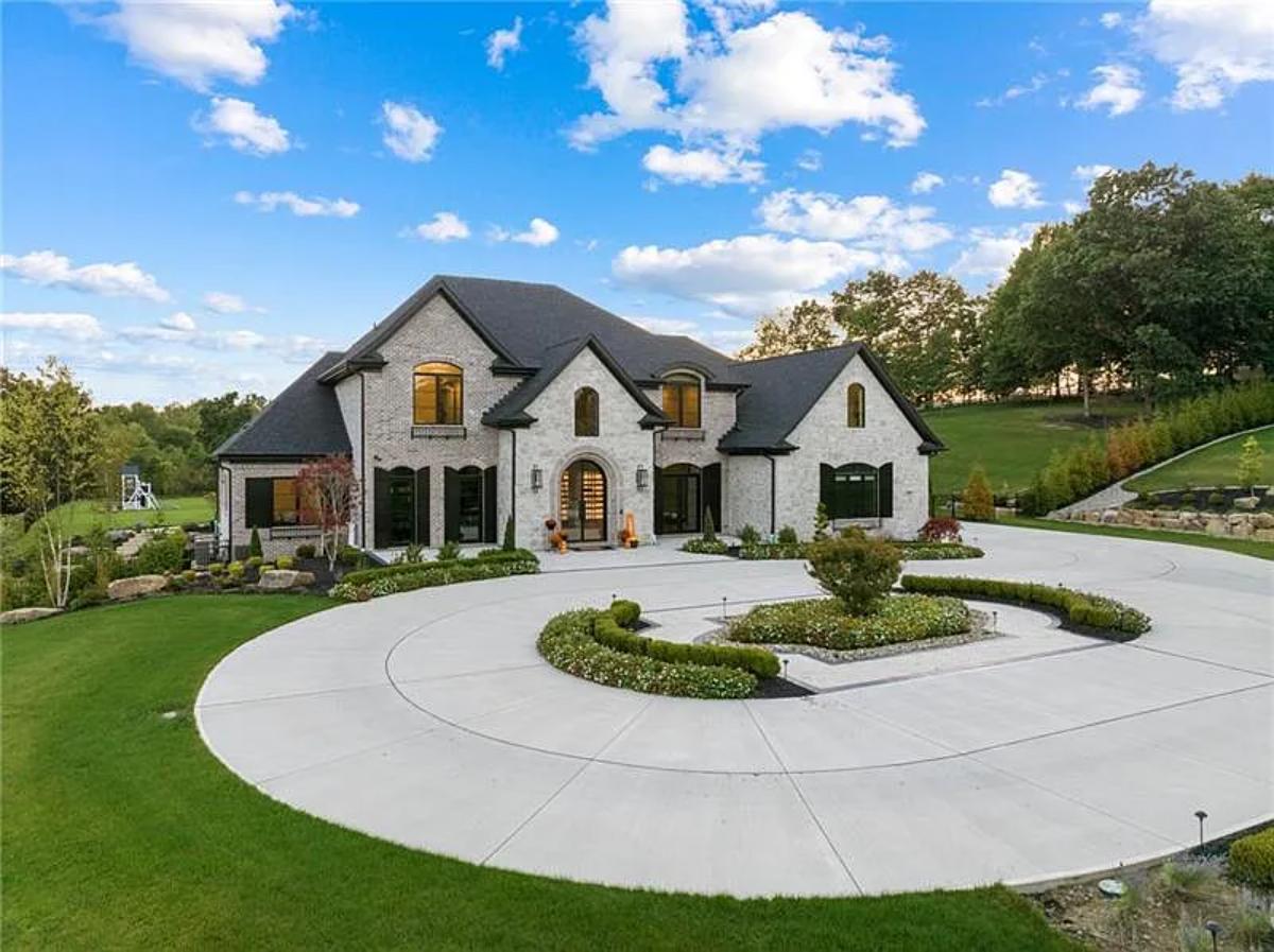 Front view of the mansion with a circular driveway.