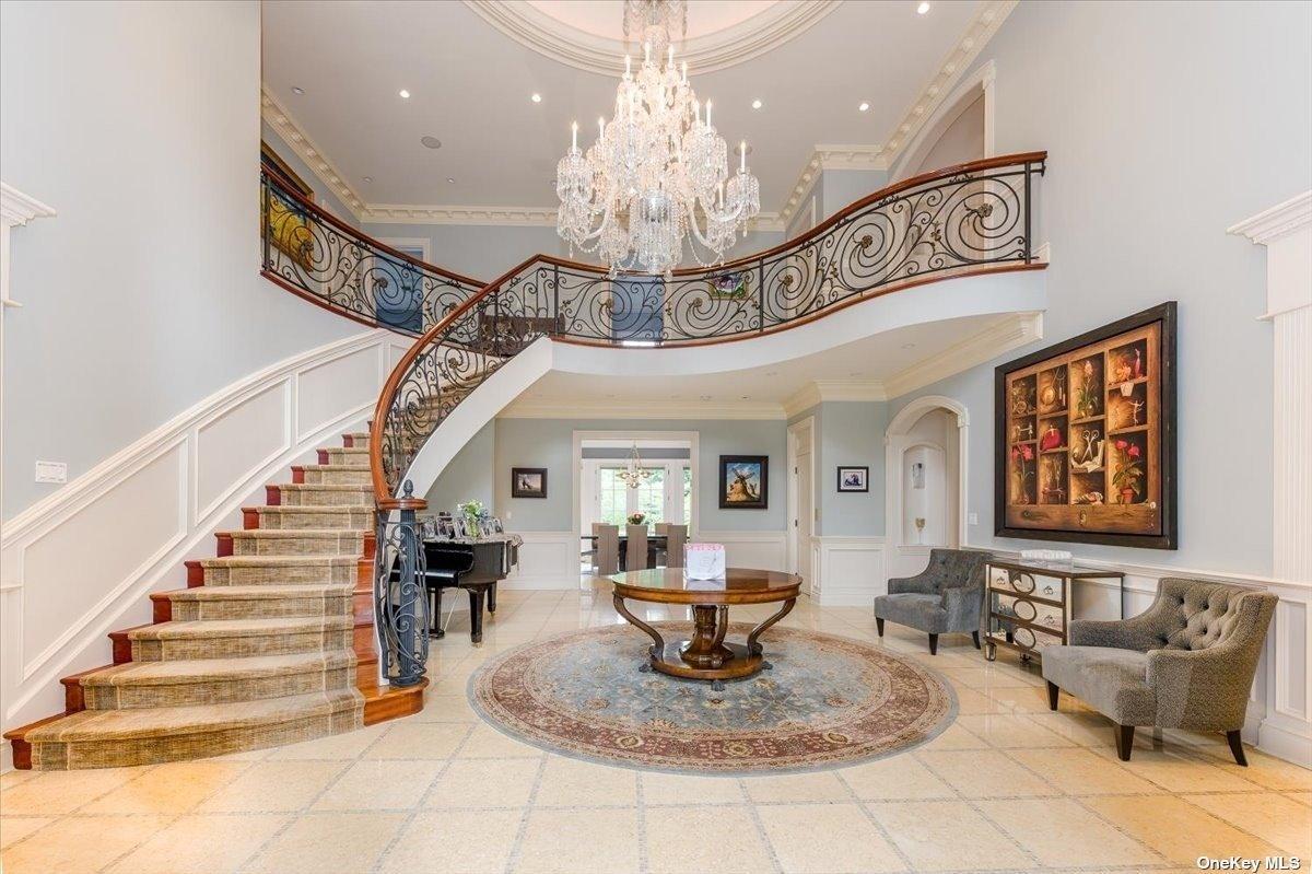 Foyer with a staircase and a chandelier.