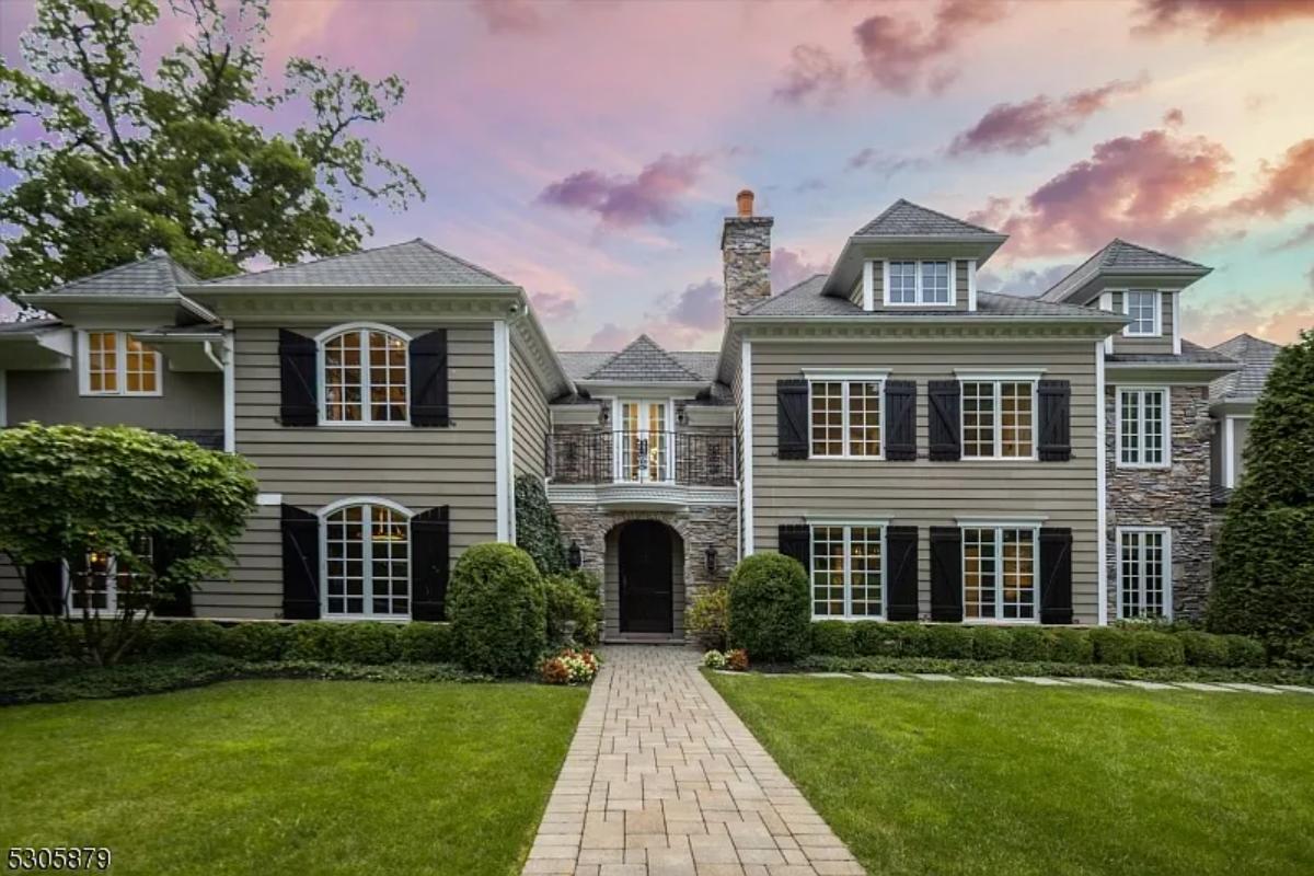 Front view of the mansion with a large green lawn.