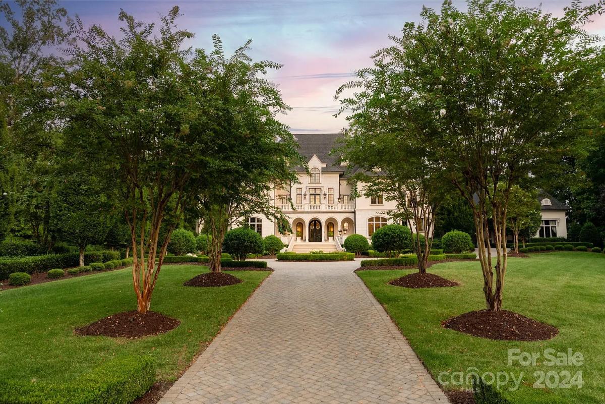 Front view of the mansion with a large green lawn.