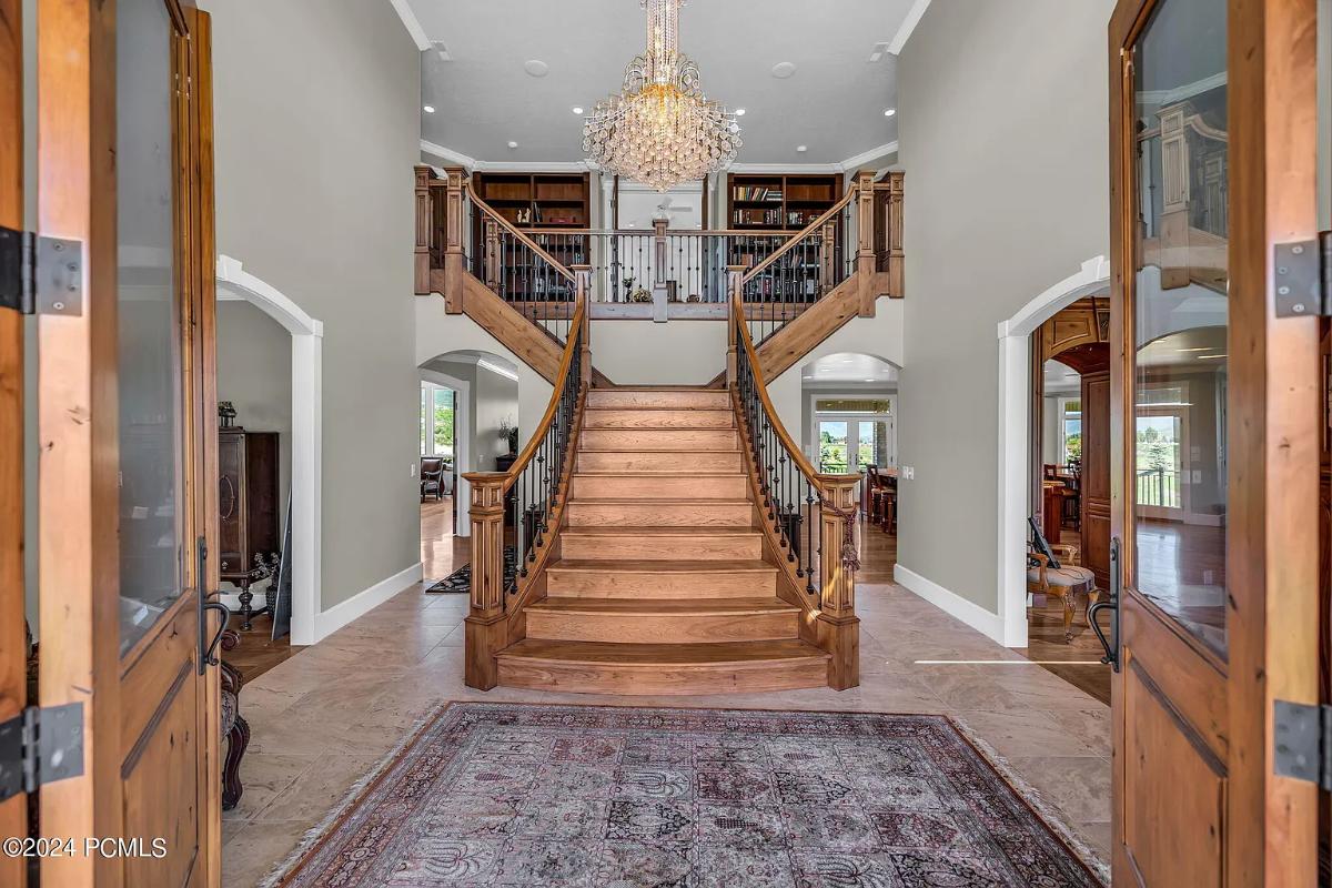 Foyer with a chandelier and stairs.