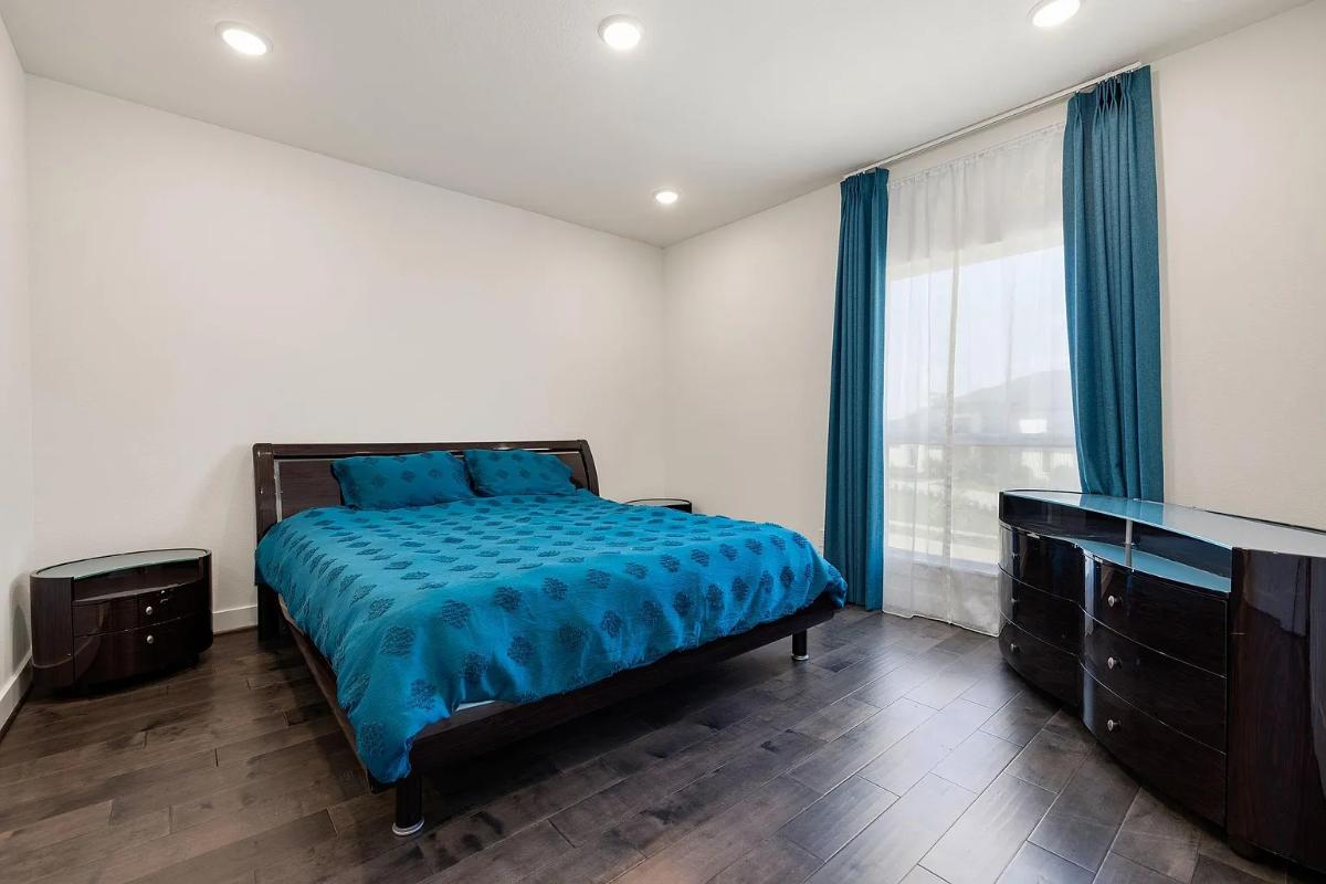 Bedroom with a large bed and hardwood floors.