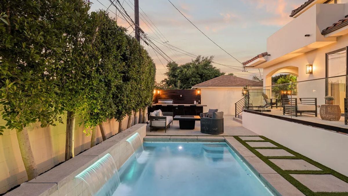 A swimming pool featuring a patio and an outdoor bar.