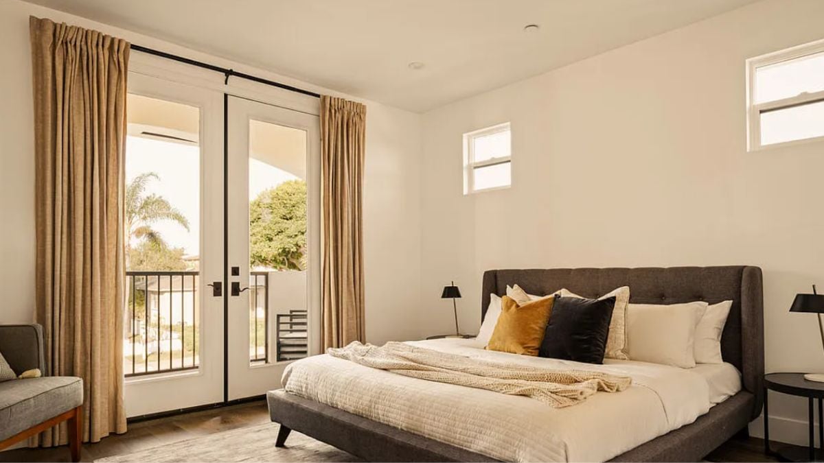 A bedroom with a bed, a nightstand, and a chair.