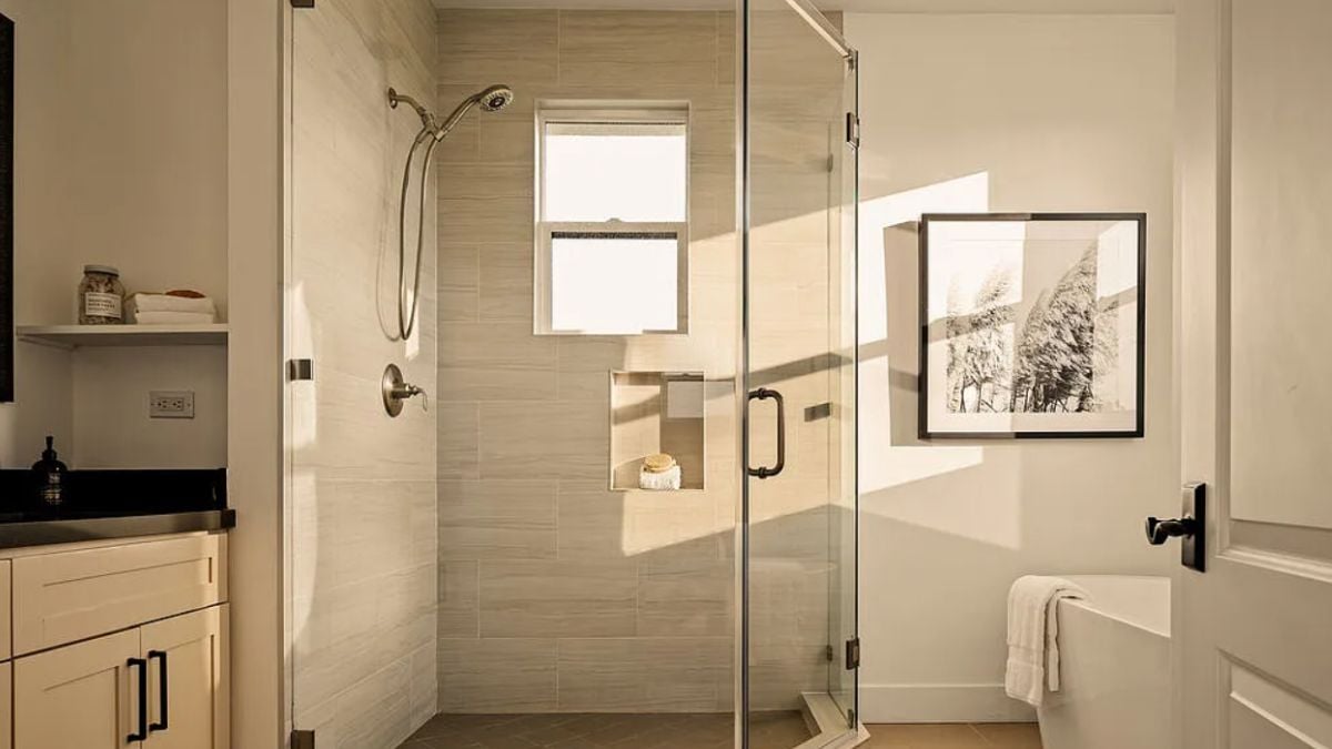 A bathroom with a vanity and a shower room.