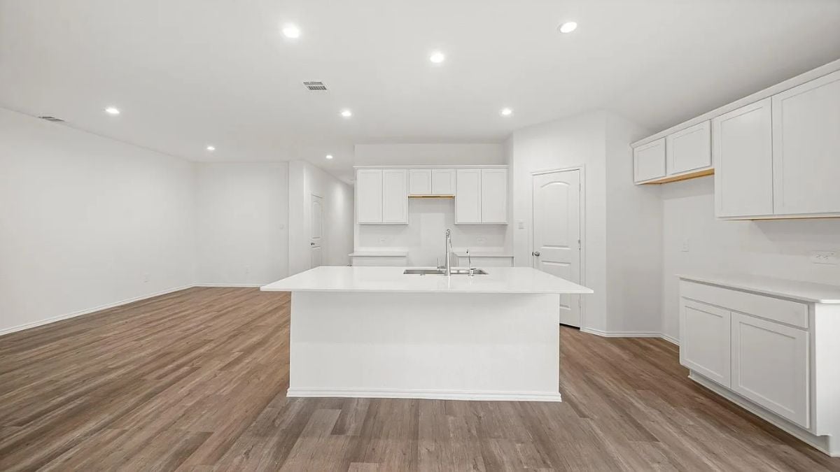 A kitchen with an island, countertops, a sink, and cabinets.
