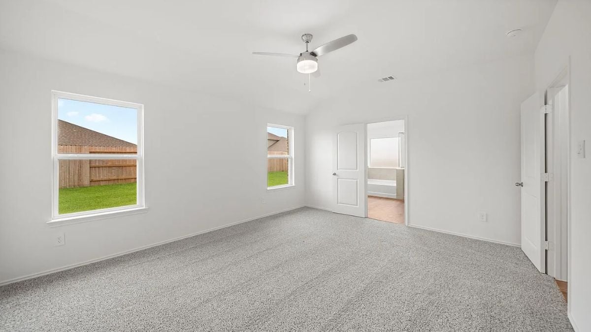 A bedroom with a bed, windows, a ceiling fan, white walls, and a white ceiling.