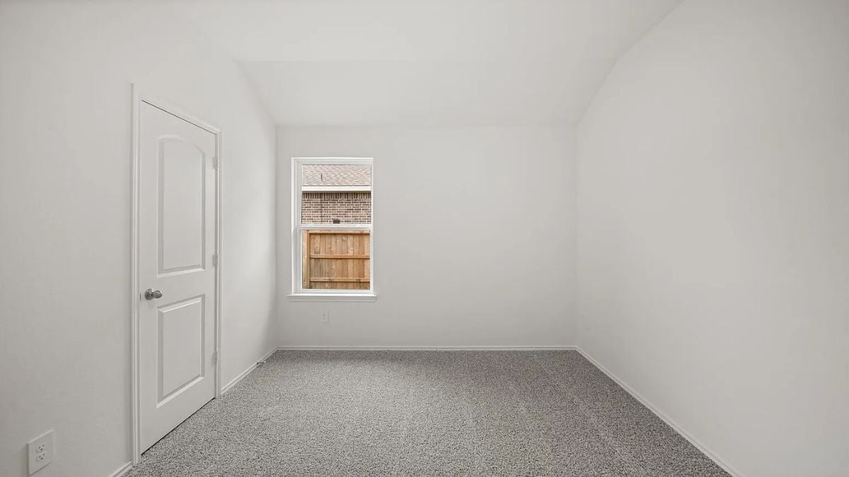 A bedroom with a bed, windows, white walls, and a white ceiling.