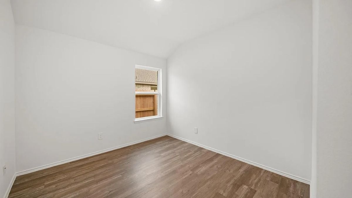 A bedroom with a bed, windows, white walls, and a white ceiling.