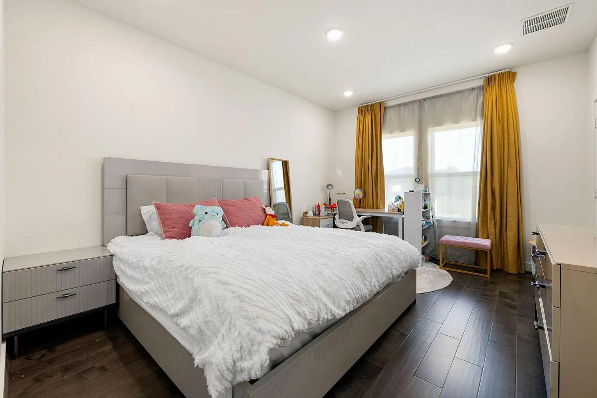 Bedroom with a large bed and hardwood floors.