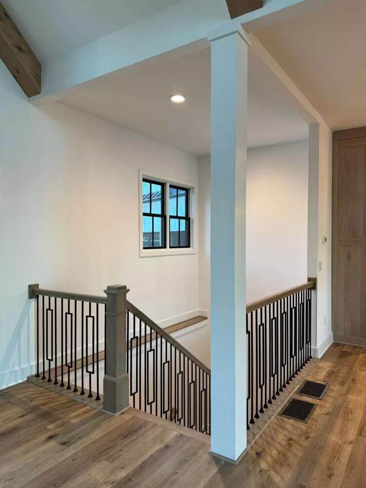 Basement stairs with wrought iron railings.