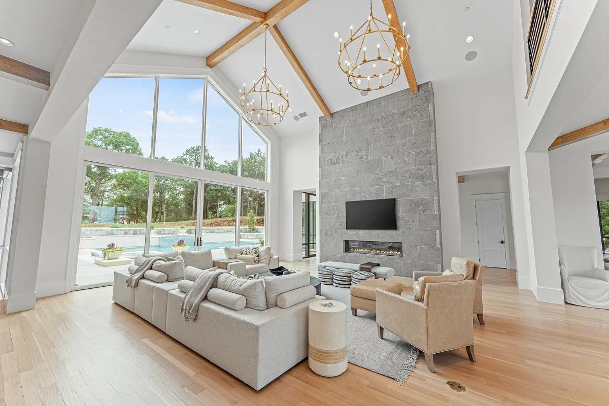 Living room with hardwood floors, high ceilings and a fireplace.