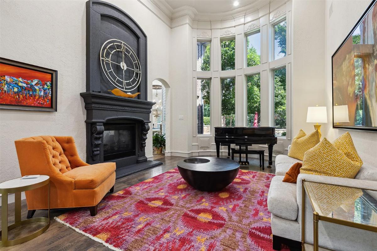 Living room with hardwood flooring, high ceilings and a fireplace.