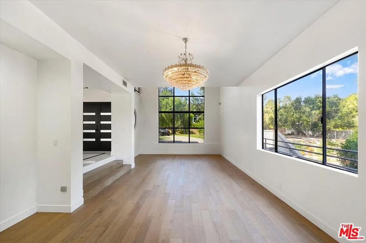 Living room with a chandelier and glass windows.