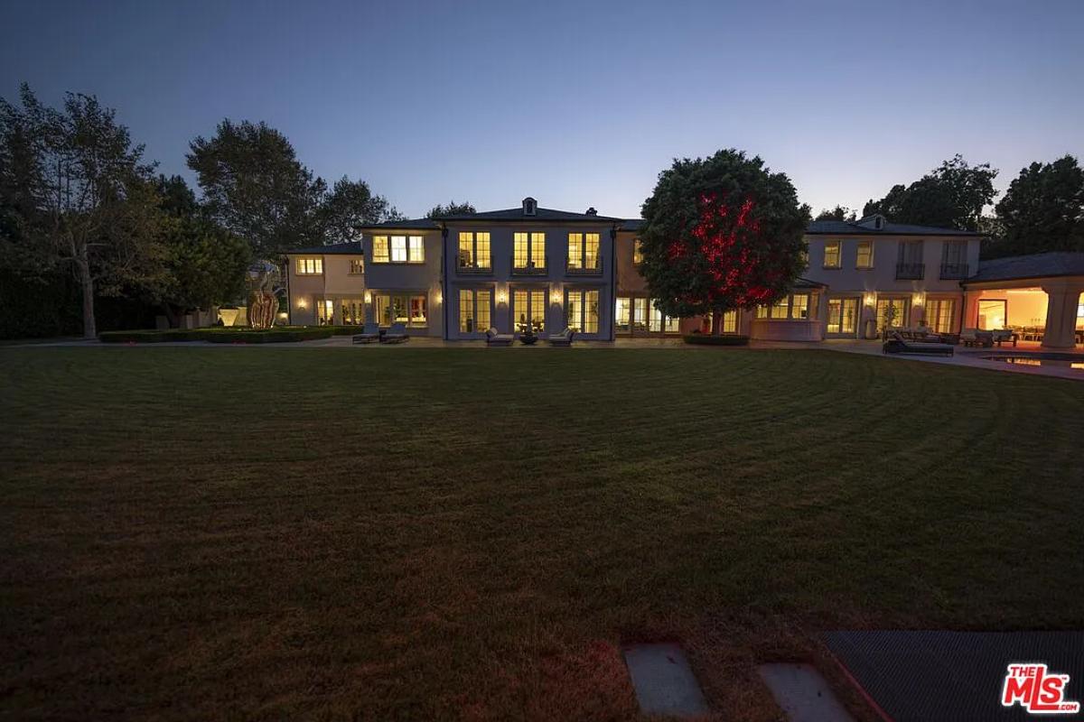 Rear view of the mansion with a large green lawn.