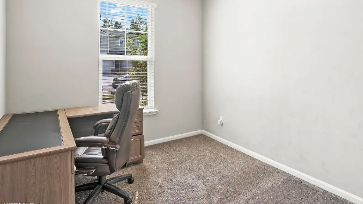 A home office with a window, a desk, and an office chair.