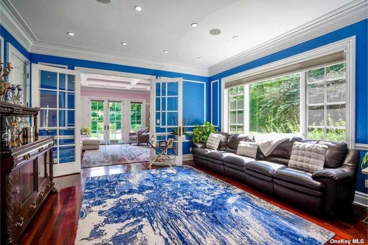 Living room with couches and hardwood flooring.