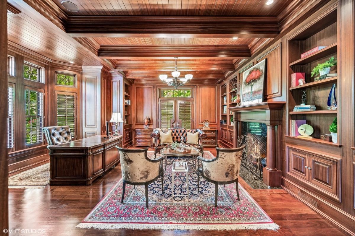 Home office with a fireplace and hardwood floors.