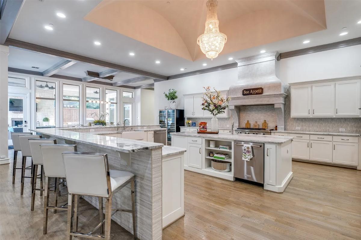 Kitchen with custom cabinetry, a counter breakfast bar and a center island prep area.
