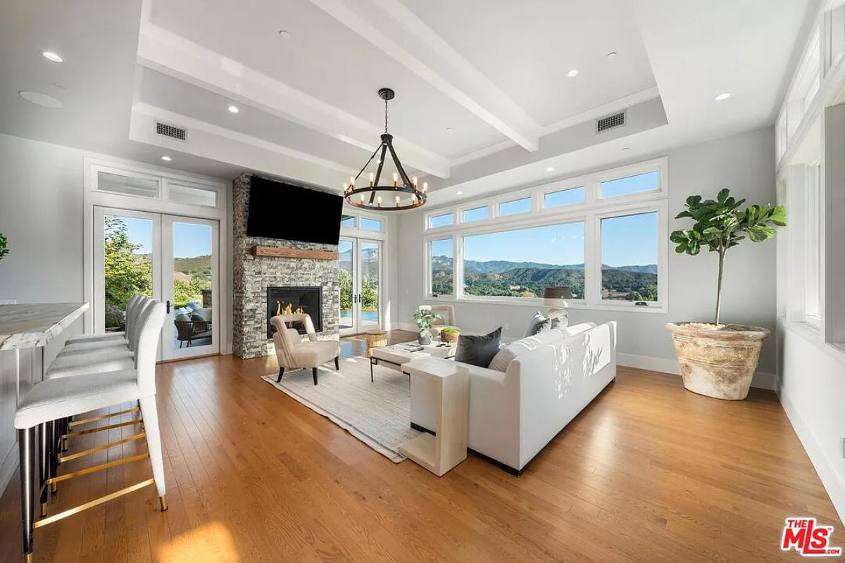 Living room with couches, hardwood floors and a fireplace.