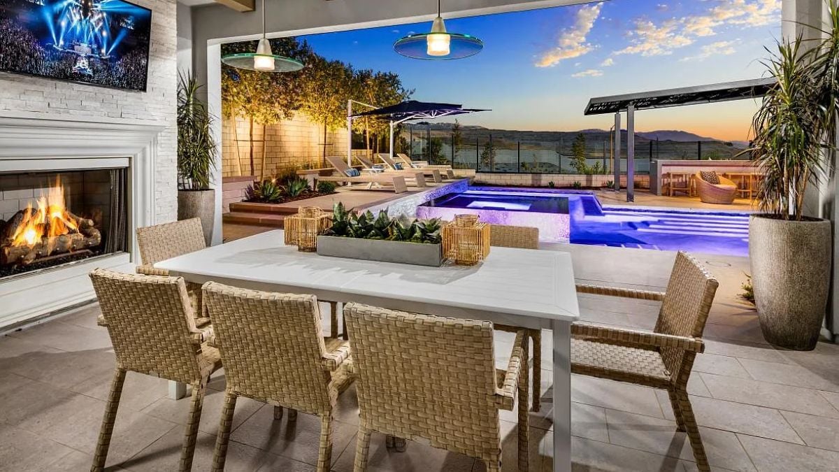 A dining area with a TV, a fireplace, and a dining table surrounded by chairs.