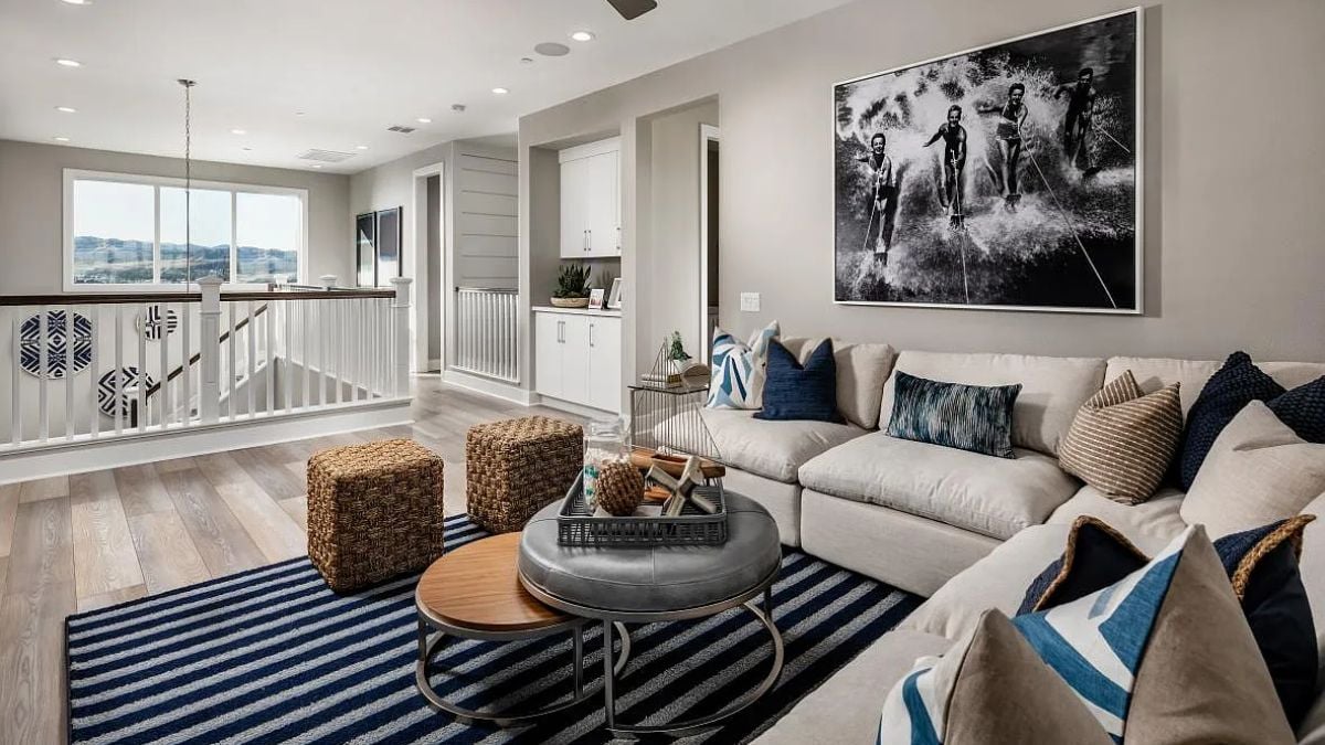 A loft with a painting, a rug, a couch, chairs, and a coffee table.