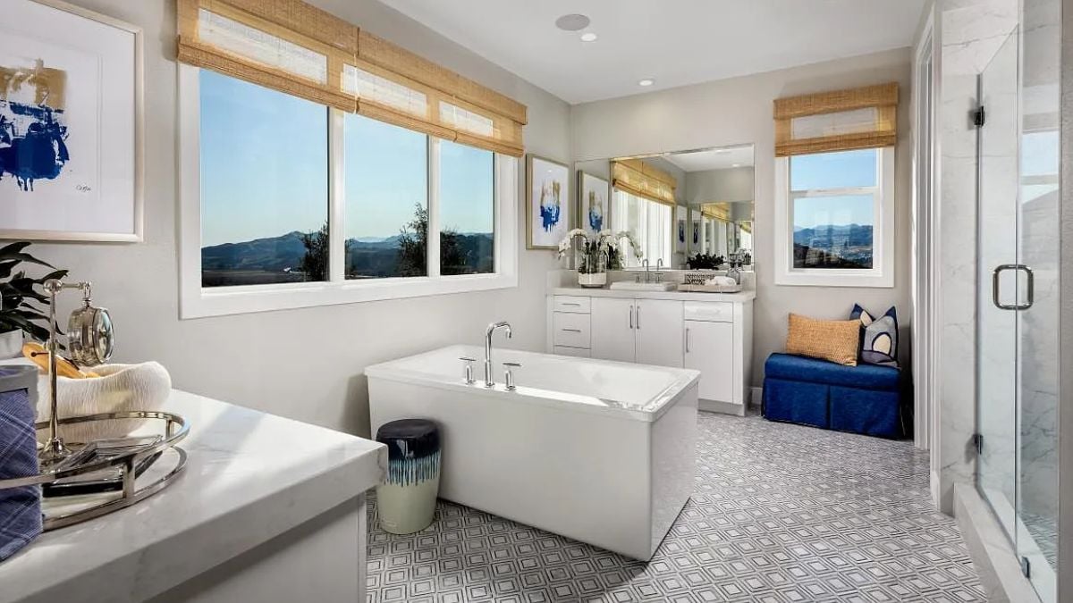 A bathroom with windows, a vanity, mirrors, and a bathtub.