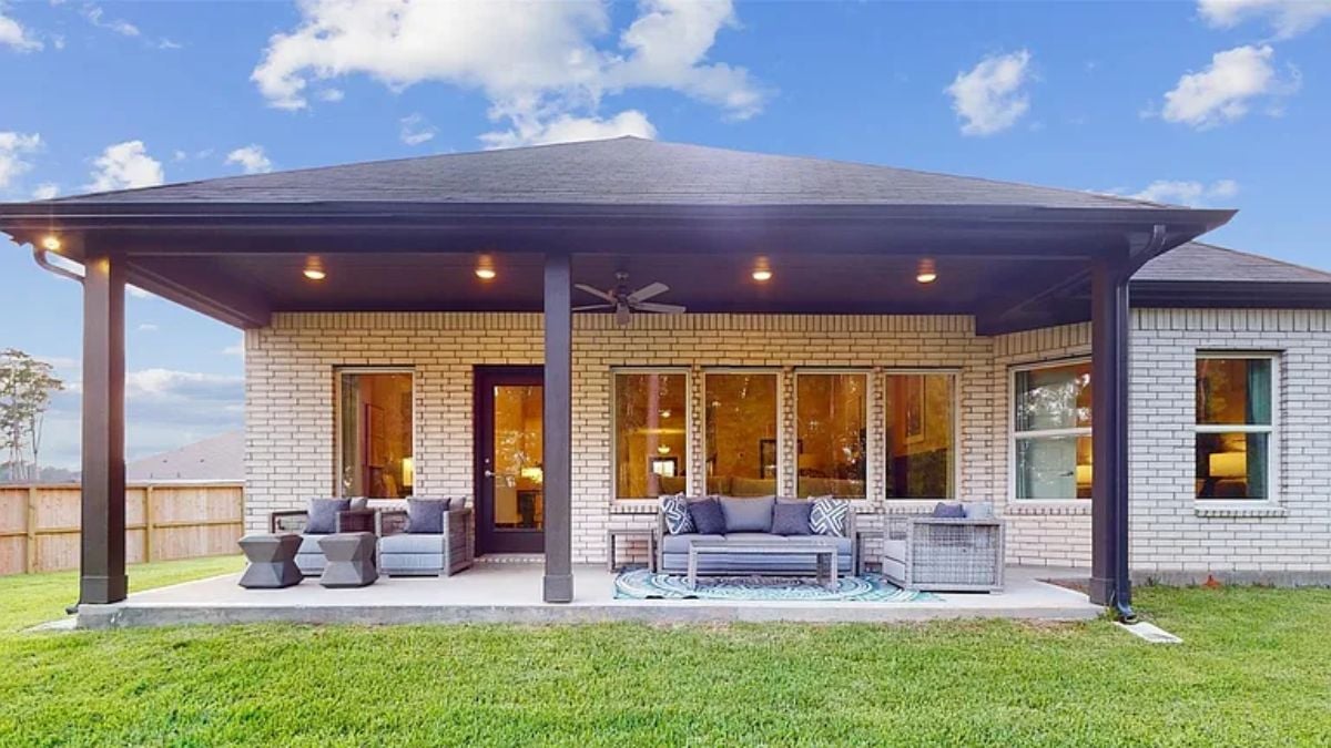 A patio with a ceiling fan, couches, chairs, and coffee tables.