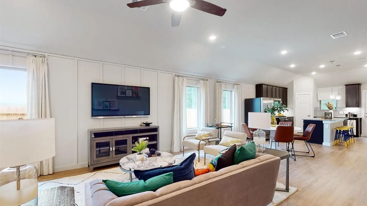 A great room with a living area, dining area, and kitchen.